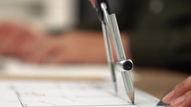 Bölücü araç ve el yazısı kullanan akıllı mimar ya da güvenlik mühendisinin videosu mimari ofisteki inşaat doğruluğu planının ayrıntılarını içeriyor. Eline odaklan. - Yakın çekim. Tanımlama.