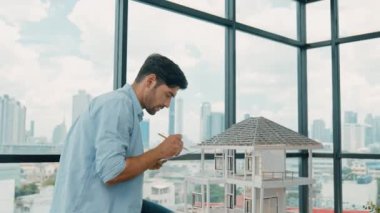Tasarımlı ev modelini karşılaştıran profesyonel mimar mühendisi. İşadamı gayrimenkul projesine yatırım yapmaya karar verdi. Proje yöneticisi planla karşılaştırarak evi kontrol ediyor. İzleme
