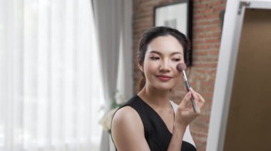 Kadın nüfuzlu kişi canlı yayın yapan video görüntülerini sosyal medya ya da blog üzerinden gözden geçiriyor. Kozmetik stüdyosu ışıklandırmalı mutlu genç kız çevrimiçi pazarlama oturumu yayını için..