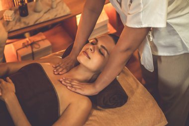 Beyaz kadın müşteri stres önleyici spa masajının keyfini çıkarıyor ve lüks otel ya da otelde sıcak mum ışığında güzellik teniyle eğleniyor. Sessiz.