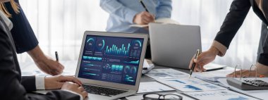 İş zekası ve veri analizi kavramı. Analizci ekibi laptop ekranında finansal veri analizi üzerinde çalışıyor. Etkili iş stratejik planlama için pazarlama göstergesi olarak. İçgörü