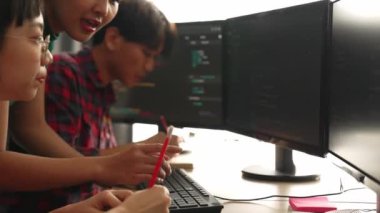 Yavaş çekim arkası yazılım geliştirici mühendisi bilgisayar programlama için birlikte çalışarak hata ayıklama kodunu çözüyor, ofiste monitörde karmaşık algoritmaları çözüyor. Filizlenen