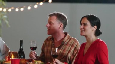 Emeklilik çifti, tatilde diğer aile üyeleriyle birlikte açık hava yemeğinde mutlu bir şekilde iyi haberlerden bahsediyorlar. İletişim eski ve genç nesil arasındaki aile bağını güçlendirir. Uyumsuzluk.