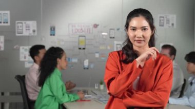 Yaratıcı iş toplantısında kendine güvenen profesyonel bir iş kadını. Çeşitli iş adamları Ux ve Ui tasarımı hakkında tartışırken kendine güvenen güzel bir lider poz veriyor. Yönlendirici.