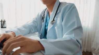 Hastanedeki doktor masasında oturup dizüstü bilgisayar üzerinde çalışıyor. Hasta test sonuçlarını teşhis ediyor, hastalıklar ve hastalıklar için tedavi planı geliştiriyor. Sağlık personeli ve sağlık hizmetleri. Ağır çekim. Katı.