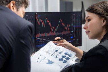 Kağıt raporunda değer istatistik şirketini tartışan iki tüccar dinamik borsa para birimini gerçek zamanlı web sitesi ofisteki bilgisayar ekranlarını çevreledi. Varsayım.