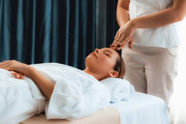 Kafkasyalı kadın stres önleyici kafa masajından ve lüks tatil beldesi ya da otel spa salonundaki modern ışık ortamında yüz güzelliği eğlencelerini şımartmaktan hoşlanıyor. Sessiz.