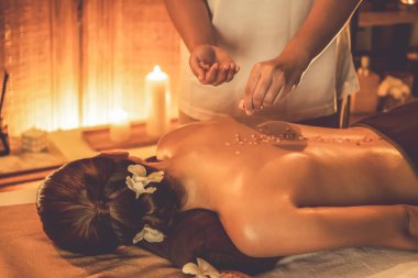 Lüks spa salonlarında sıcak mum ışığında cilt bakımı yaptıran kadın müşteri. Sağlık Spa vücut fırçasında tuz temizleme güzellik tedavisi. Sessiz.