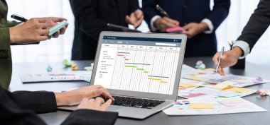 Analizci ekibi yaratıcı ve analitik beyin fırtınası fikri için bilgisayar ekranında BI veri paneli olan yapışkan bir not kullanıyor. Pazarlama stratejisi için finansal veri görselleştirme teknolojisini analiz et. Dahi.