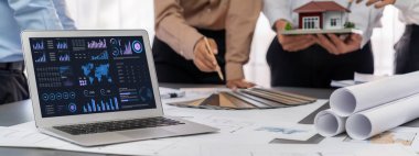 İç mimar tasarımcı grubu, daha kesin tasarım için planlar ve dizüstü bilgisayar ekran mimari yazılımı üzerinde birlikte tartışıyorlar. Modern ev tasarımı ve yenileme. İçgörü