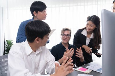 Bir grup farklı ofis çalışanı şirket ofis odasında stratejik iş pazarlama planlamasında birlikte çalışıyor. İş yeri konseptinde pozitif takım çalışması. Tedbirli