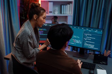 Akıllı bilişim geliştiricisi bilgisayar ekranındaki çevrimiçi web sitesinde kodlama programı uygulamasına bakıyor, ofisteki iş pazarlamasında akıllı veritabanı geliştirme sistemini analiz ediyor. İnfobahn.