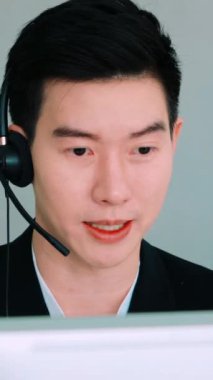 Ofiste çalışan kulaklık takan işadamları uzak müşteri ya da meslektaşlarını desteklemek için çalışıyorlar. Arama merkezi, tele pazarlama, müşteri destek acentesi telefon görüşmesinde hizmet sunar.