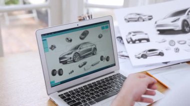 Araba tasarım mühendisi otomobil işi için otomobil prototipini ev ofisinde analiz ediyor. Otomotiv mühendisliği tasarımcısı dikkatle analiz eder, kusurları bulur ve dizüstü bilgisayarla araba tasarımında gelişmeler kaydeder.
