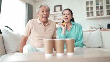 Konsantrasyonu ve odaklanmayı geliştirmek için masa atma oyunu oynayan çift. Büyükannem oturma odasında bir noktayı kaçırırken büyükbabam karısını cesaretlendiriyor ve destekliyor. Koruyucu sağlık hizmeti. Myrmidon.