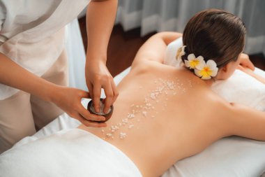 Lüks spa salonlarında sıcak mum ışığında cilt bakımı yaptıran kadın müşteri. Sağlık Spa vücut fırçasında tuz temizleme güzellik tedavisi. Sessiz.