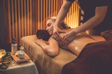 Beyaz kadın müşteri stres önleyici spa masajının keyfini çıkarıyor ve lüks otel ya da otelde sıcak mum ışığında güzellik teniyle eğleniyor. Sessiz.