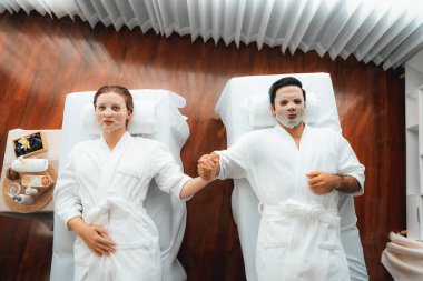 Kaplıca salonunun sakin, modern gündüz atmosferi, birkaç müşteri yüz maskesi takarak kendini yenilemeye çalışıyor. Yüz bakımı ve güzellik kozmetolojisi prosedürü. Sessiz.