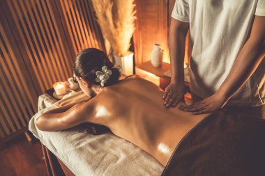 Beyaz kadın müşteri stres önleyici spa masajının keyfini çıkarıyor ve lüks otel ya da otelde sıcak mum ışığında güzellik teniyle eğleniyor. Sessiz.