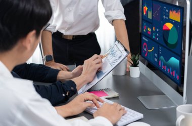 Veri analistleri, mali, trend ve pazarlama verilerini analiz etmek için dizüstü bilgisayardaki iş zekası veri göstergesini analiz ediyor. İş başarısı için BI teknolojisi ve veri analizi. Tedbirli