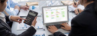 İş zekası ve veri analizi kavramı. Analizci ekibi laptop ekranında finansal veri analizi üzerinde çalışıyor. Etkili iş stratejik planlama için pazarlama göstergesi olarak. İçgörü