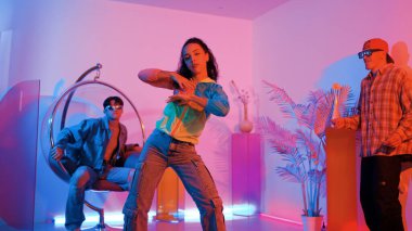 Çekici mutlu dansçı kameraya bakarken zeki kadın neon ışıkla kafiyeli hareket ediyor. Profesyonel İspanyol şarkıcı çeşitli arkadaşlarıyla renkli kıyafetler giyerken break dans yapıyor. Mutluluk.