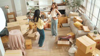 Taşınırken oturma odasında mutlu lezbiyen aşıklar dans ediyor. Birkaç arkadaş müzik eşliğinde salonda karton kutularla dans ederek serbest dans ediyorlar. Yeniden yerleştirme. Myrmidon.