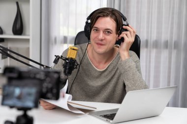 Akıllı yayıncının sunucu kanalı canlı sosyal medya yayını ile dinleyicilere senaryo okuyarak, kulaklık takarak modern ev stüdyosundaki video flamalarını kaydediyor. Bireysel.