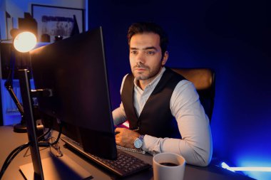 Akıllı iş adamı, gece geç saatlerde Mor Neon Loş Işıklı Ev Ofisi 'nde bilgisayar ekranında hizmet ürün veritabanı satış kanalında araştırma hedef pazarı ile birlikte çalışıyor. Tahmin et..