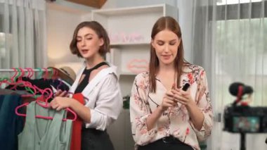 İki kadın nüfuzlu kişi canlı yayın yapan video klip eleştirisi kıyafetlerini sosyal medyada ya da blogda yayınlıyor. Stüdyo ışıklandırmalı mutlu genç kız çevrimiçi pazarlama oturumu yayını için..