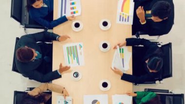 İş adamları grup toplantısı ofiste yukarıdan çekildi. İş kadınları, iş adamları ve ofis çalışanları, proje planlama belgeleriyle takım konferansında toplantı masasında çalışıyorlar. .