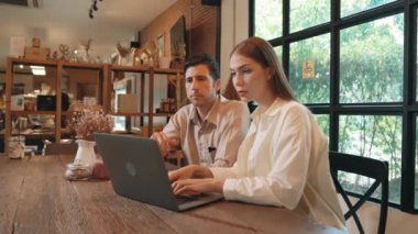 Baharda Cafe Garden 'da dizüstü bilgisayarda çalışan genç bir çift kahve dükkanındaki dinginlik ortamının tadını çıkarıyor. Uzaktan çalışan ya da blog yazan dijital göçebe ya da üniversite öğrencisi. Yararlı