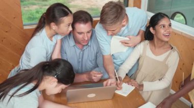 Kafkas öğretmenler dersi dizüstü bilgisayar kullanarak öğretirken öğrencilerin en üst görüşü soru sorar. Zeki eğitmen etrafını dinleyen ve ders veren çeşitli öğrencilerle çevrili olan projeyi açıklıyor. Öğretim