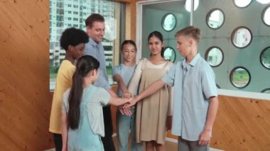 Kafkas öğretmeni ve çeşitli çocuklar sınıfta ayakta dururken başarılı projeyi kutlamak için el ele tutuşuyorlar. Aşkı, takım çalışmasını, güveni, birlikteliği ve birliği temsil et. Öğretim