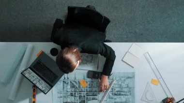 İş kadınının proje planı, ekipman ve güvenlik kaskıyla toplantı masasında oturan mühendis el planının en üst görüntüsü. Yöneticinin hava görüntüsü bina inşaatını açıklıyor. Hizalama.