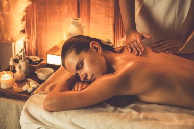 Beyaz kadın müşteri stres önleyici spa masajının keyfini çıkarıyor ve lüks otel ya da otelde sıcak mum ışığında güzellik teniyle eğleniyor. Sessiz.