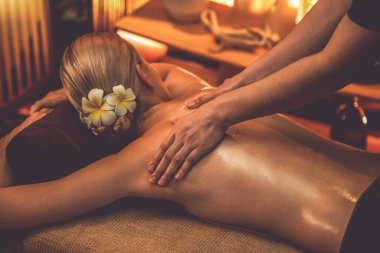 Beyaz kadın müşteri stres önleyici spa masajının keyfini çıkarıyor ve lüks otel ya da otelde sıcak mum ışığında güzellik teniyle eğleniyor. Sessiz.