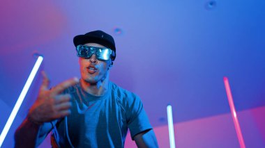 Beyaz dansçının gösterişli gözlükler taktığı ve break dans yaptığı alçak açılı kamera. Çekici adam kendinden emin bir şekilde kameraya bakarken enerjik bir performans ve hareket gösterdi. Mutluluk.