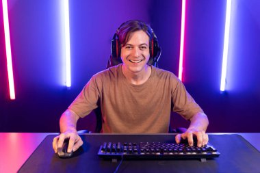 Kazanmak için çevrimiçi oyun oynayan akıllı flama makinesinin sunucu kanalı, neon ışıklı odada seçilen takım yarışması için izleyicilerle birlikte canlı yayında canlı yayında kulaklık takıyor. Bireysel.