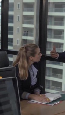 Kıdemli lider takım üyelerine tavsiye konuşması yapıyor. Modern ofisteki masada yaratıcı iş adamları buluşuyor. Çok kültürlü iş ekibi..