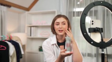 Kadın nüfuzlu kişi sosyal medya ya da blog için canlı yayın yapan video klip eleştirmeni Cilt Bakımı 'nı çekiyor. Kozmetik stüdyosu ışıklandırmalı mutlu genç kız çevrimiçi pazarlama oturumu yayını için..