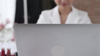 Çalışma masasında internet içeriği için dizüstü bilgisayar kullanan ya da evden çalışan genç bir iş kadını. Kıyafet ve tekstil işi pazarlama analizi. Canlılık