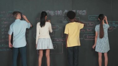 Çeşitli çocuklar kara tahta kullanarak program kodlamayı planlıyor. BTMM dersinde programlama sistemini öğrenirken karışık ırk yazarlığı ya da yaratıcı fikir üreten insanlar. Öğretim