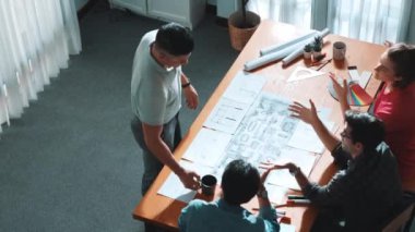 Proje yöneticisi çalışırken ve kahve içerken iç mimari planlama binasının üst görüntüsü. Bir grup mühendis fikir üretiyor ve fikir sunarken ev yapısını tasarlıyor. Sempozyum.