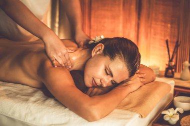 Beyaz kadın müşteri stres önleyici spa masajının keyfini çıkarıyor ve lüks otel ya da otelde sıcak mum ışığında güzellik teniyle eğleniyor. Sessiz.