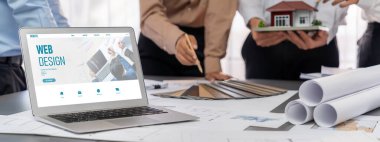 İç mimar tasarımcı grubu, daha kesin tasarım için planlar ve dizüstü bilgisayar ekran mimari yazılımı üzerinde birlikte tartışıyorlar. Modern ev tasarımı ve yenileme. İçgörü