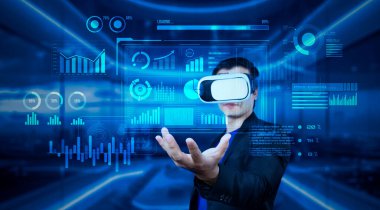 VR gözlüklü proje yöneticisi elinde mali tablo ve ofiste parlayan mavi ışık tutuyor. Yetenekli iş adamı artırılmış gerçeklikten elde edilen verileri kullanarak pazarlama stratejisini kontrol edip planlıyor. Yaratıcılık.