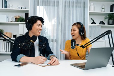 Gülümseyen radyo etkili sunucular, kulaklık takarak sosyal medya kanalından canlı yayın yapıyorlar ve sabah saatlerinde stüdyo kaydında dinleyicilere konu ve dizüstü bilgisayar üzerinden konuşuyorlar. İnfobahn.