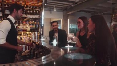 Gece kulübündeki lüks gece kulübünde, içki tezgahında çalışan akıllı barmen servisinde çift ya da arkadaş grubuyla gülen VIP müşterilere özel cin kokteyli servisi. Vinosity.