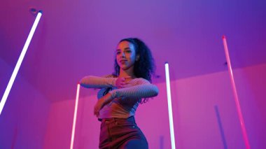 Latin dansçıların kameraya bakıp şehrin pop müziğiyle dans ettiği düşük açılı kamera. Profesyonel çekici hipster, mor veya neon ışıklı hip hop şarkısına geçiyor. Şık bir kumaş. Mutluluk.